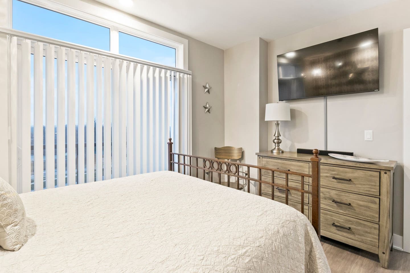 Bedroom with metal bed frame and wooden dresser