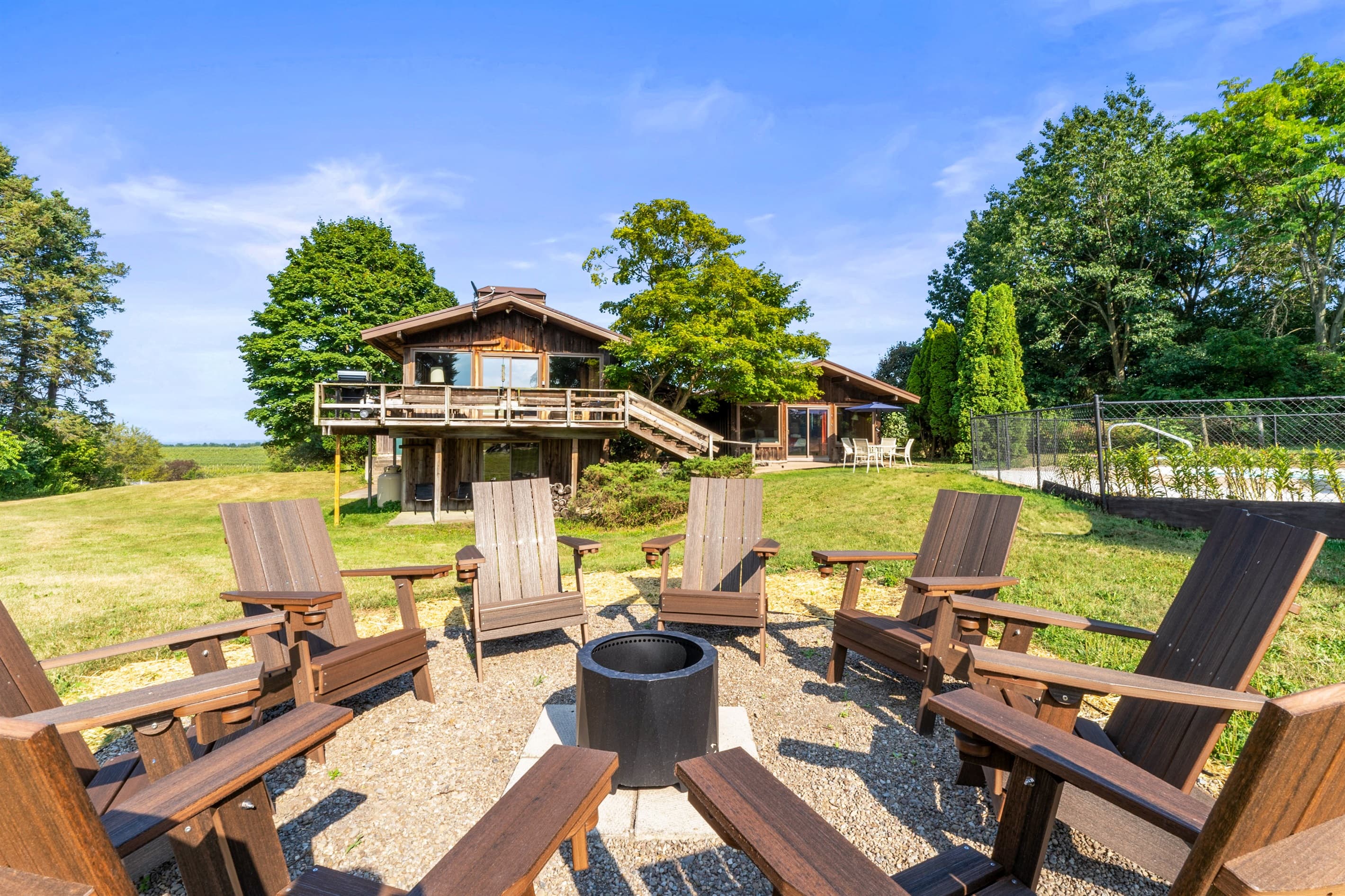 Fire pit surrounded by Adirondack chairs