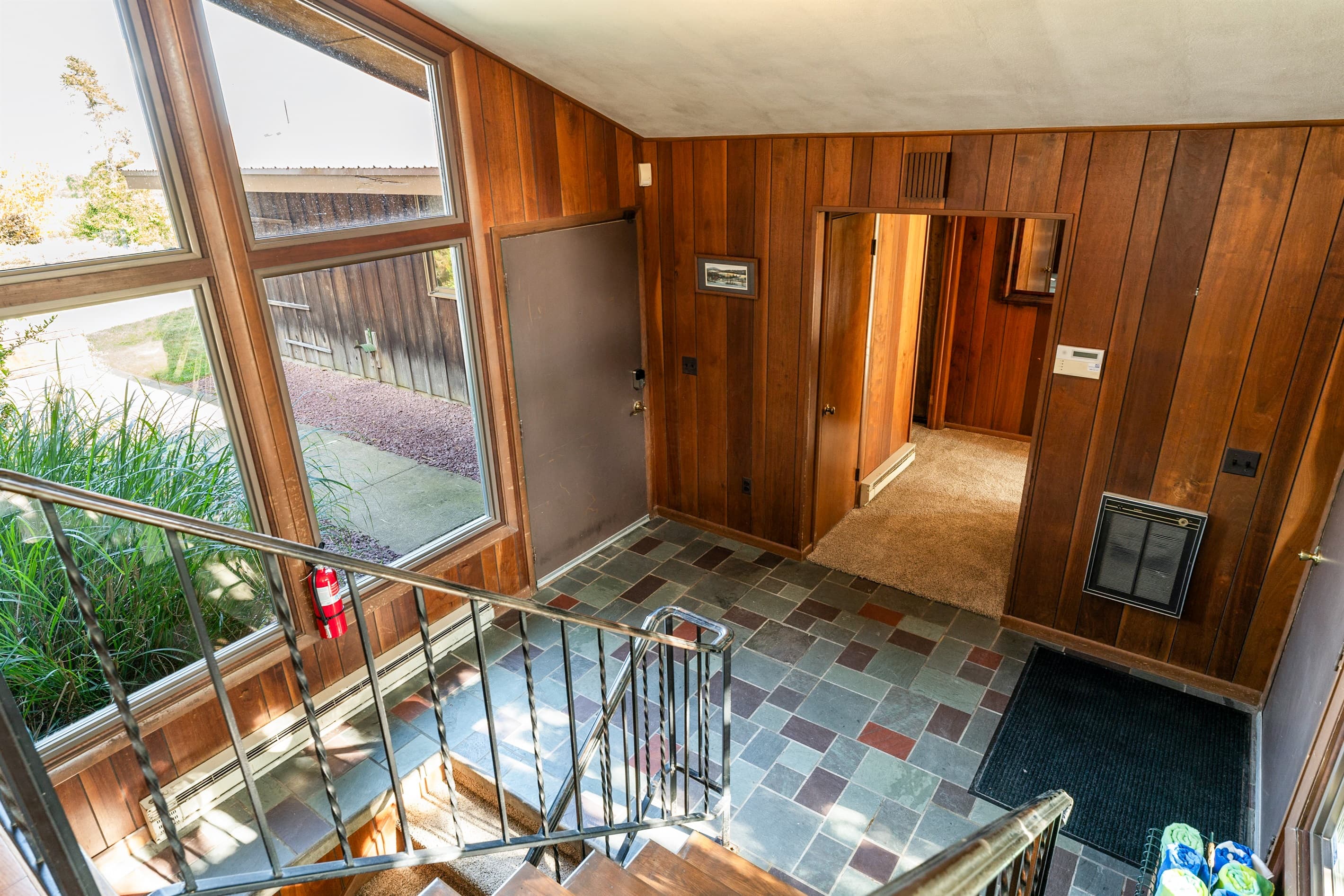 Wood-paneled foyer with slate tile flooring