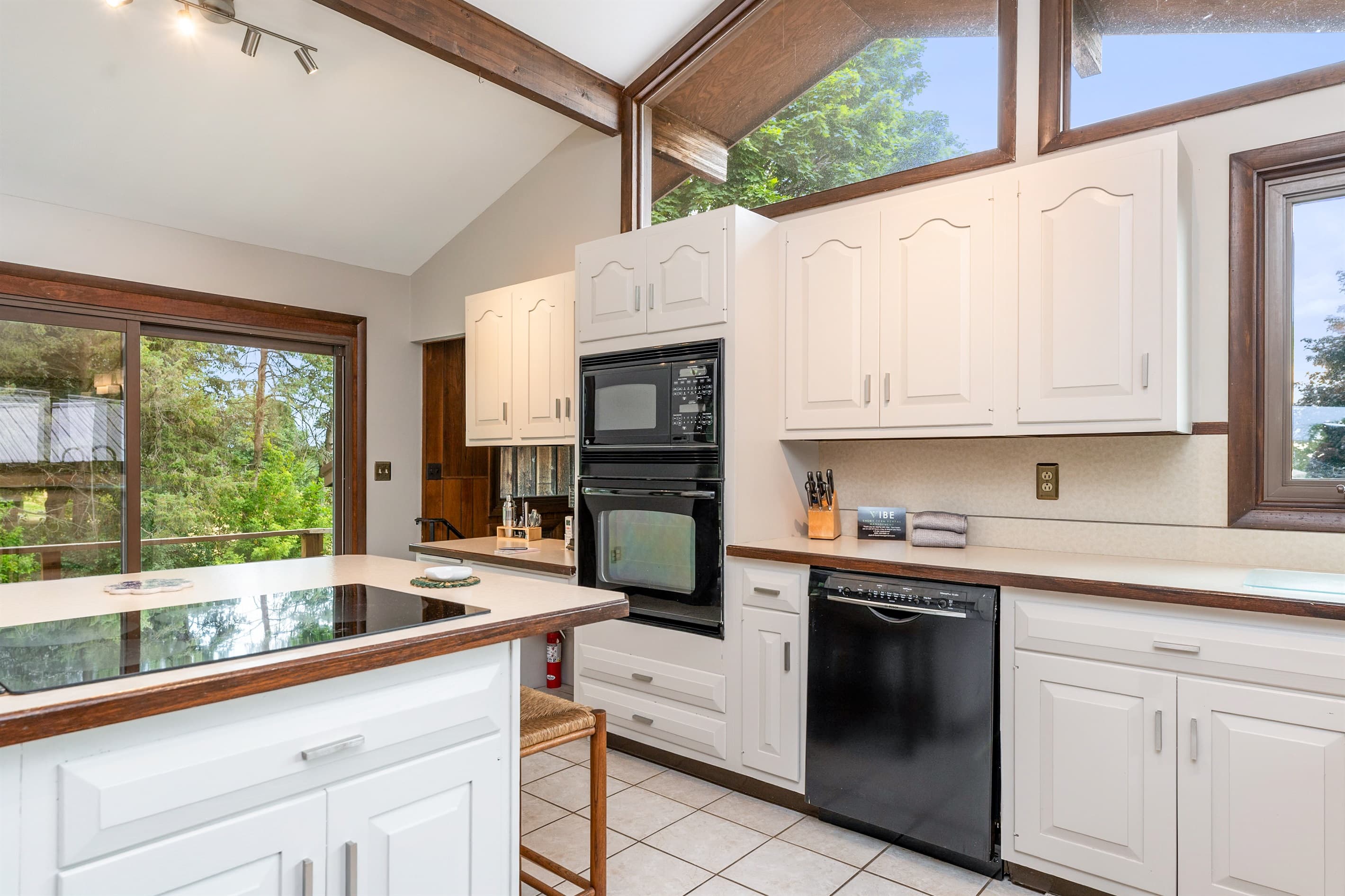 Vaulted kitchen with white cabinetry and peninsula