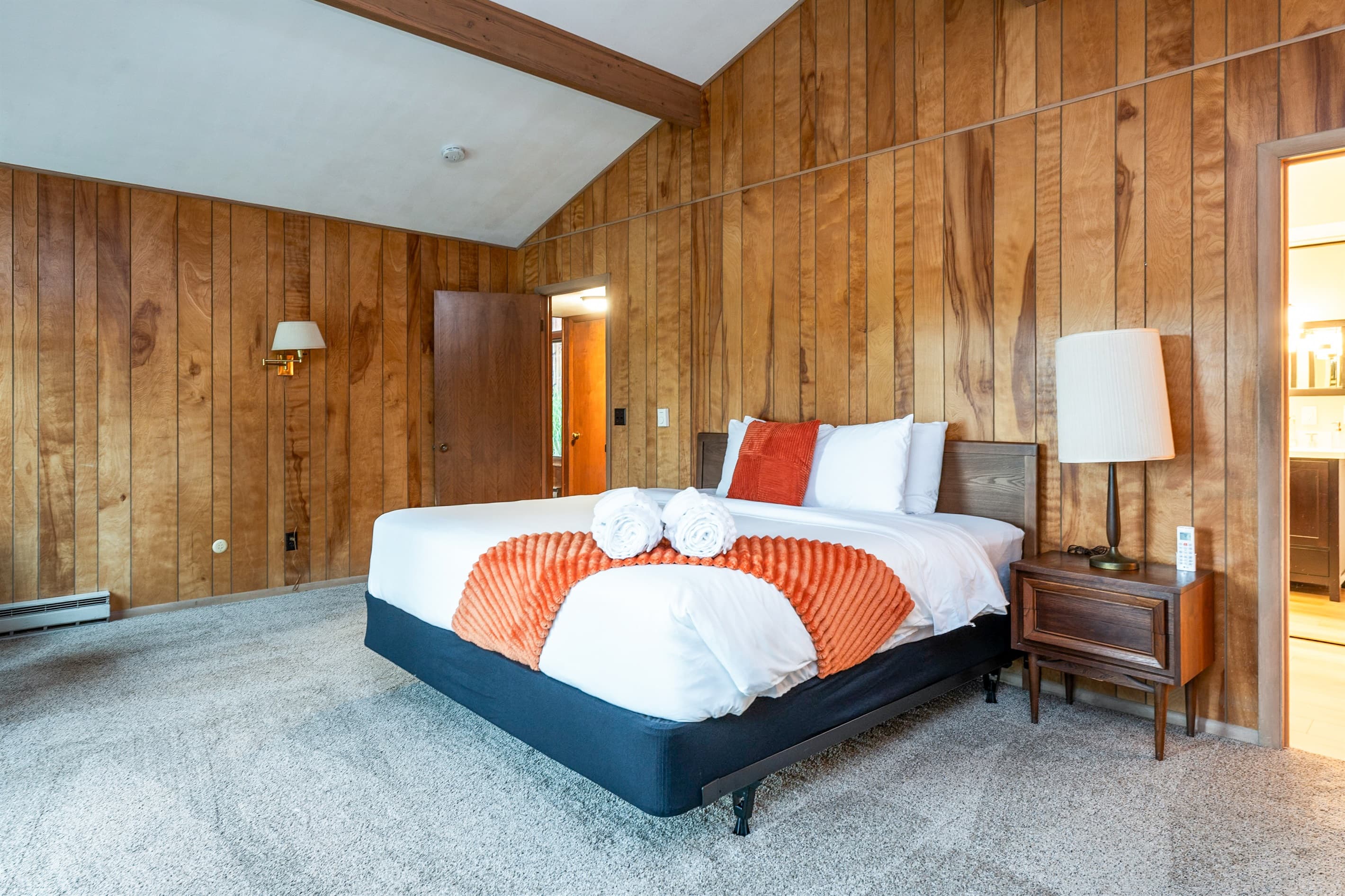 Wood-paneled king bedroom with vaulted ceiling