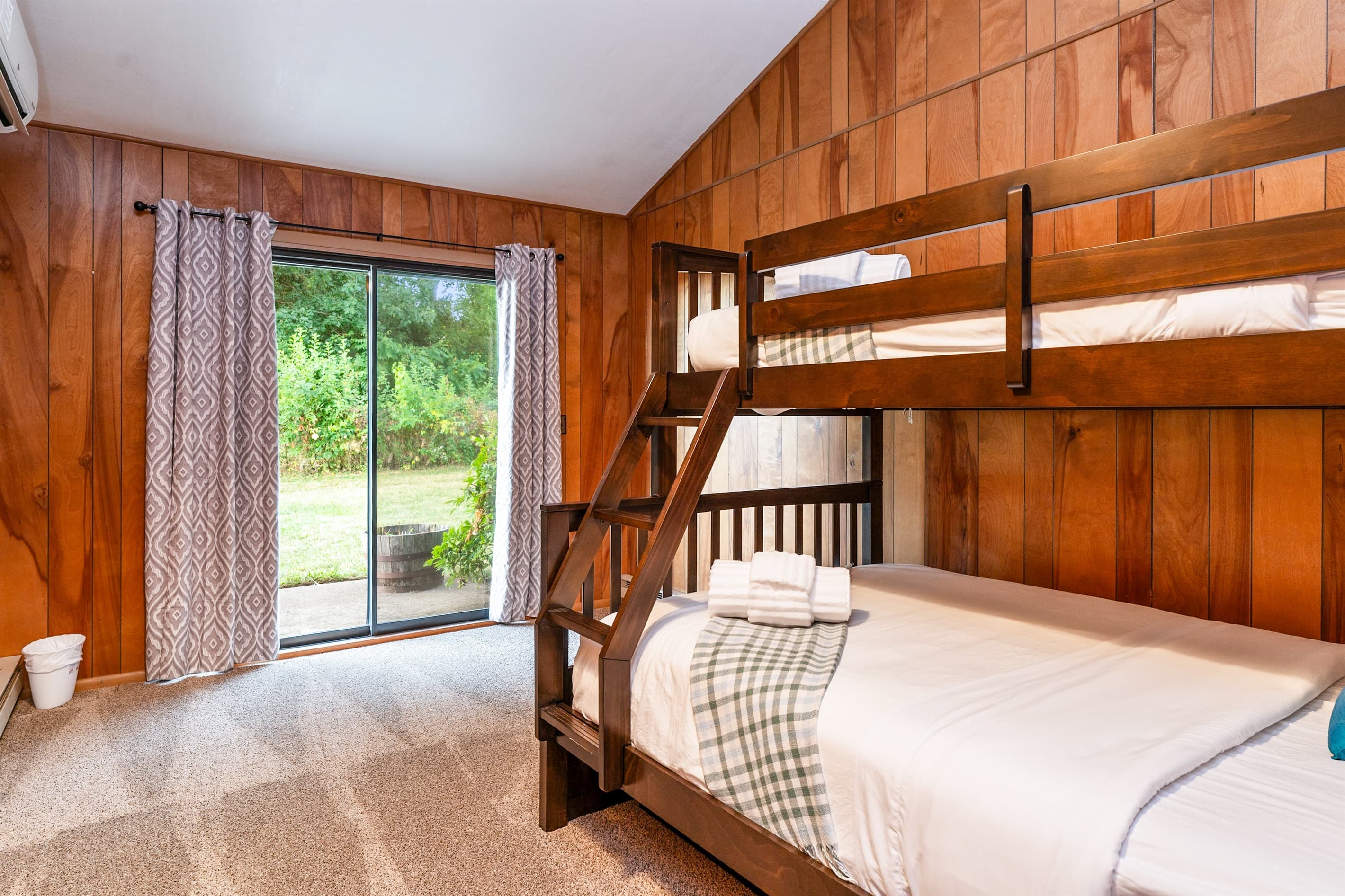 Wood-paneled bunk room with sliding glass doors 