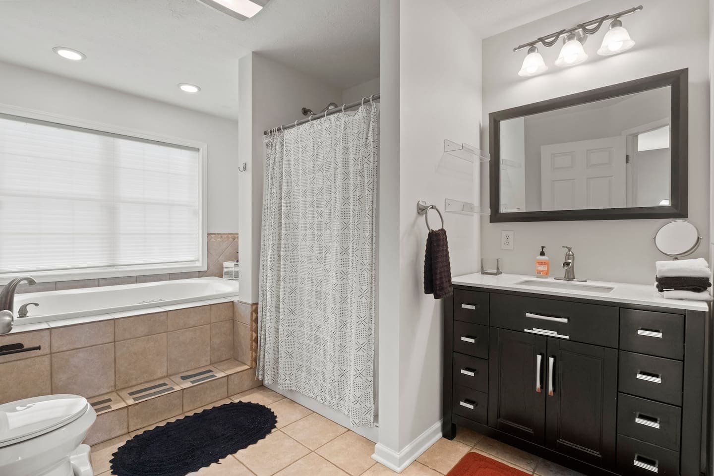 Bathroom with dark vanity and walk-in shower