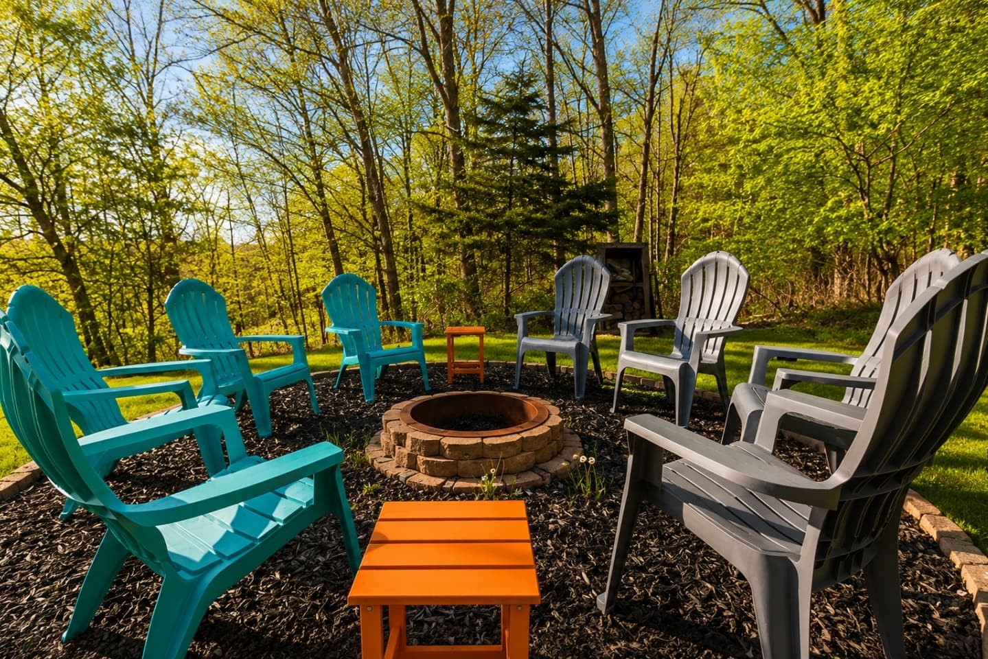 Wooded fire pit area with Adirondack chairs