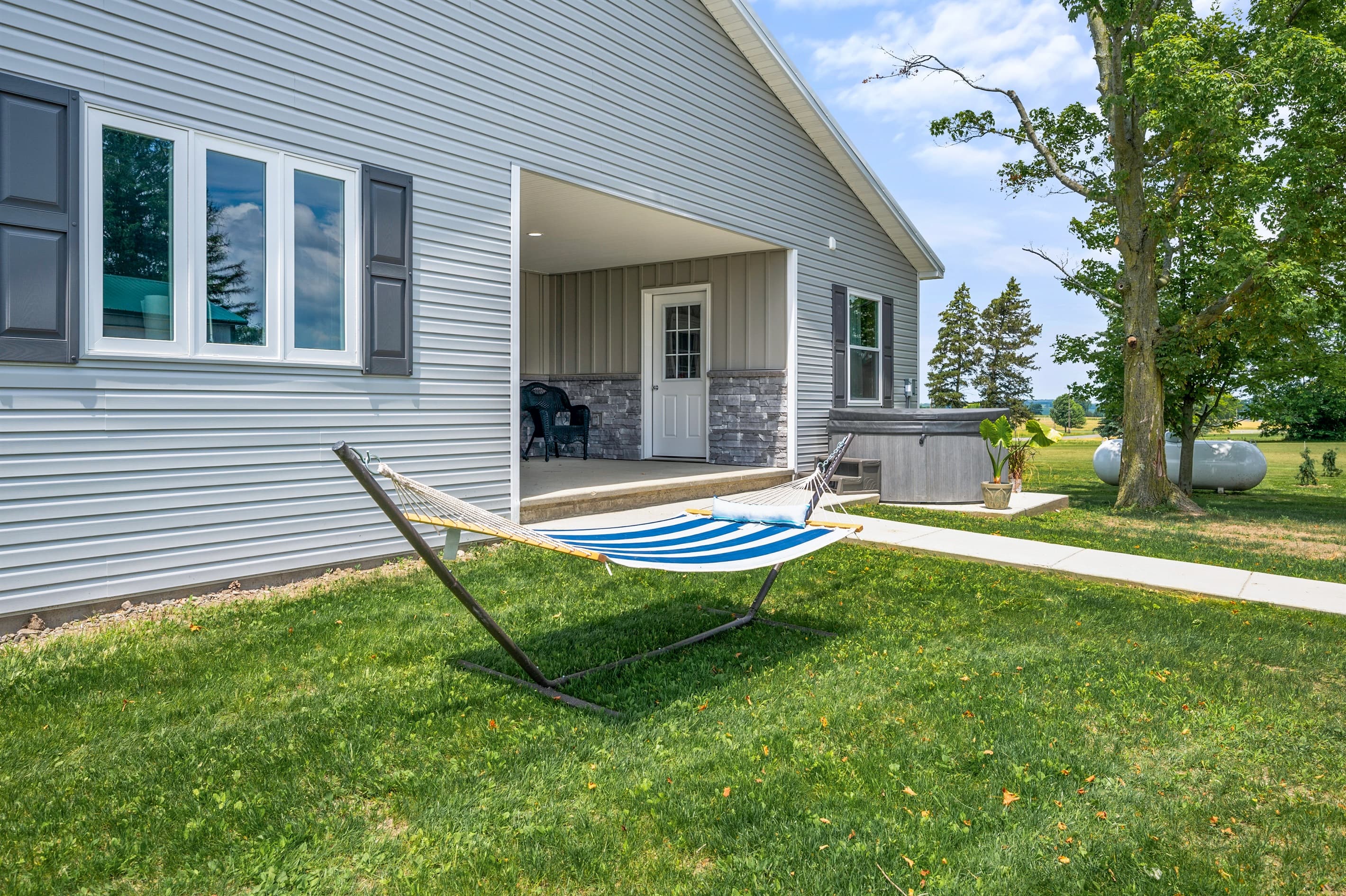 Side exterior with a hammock and covered entryway