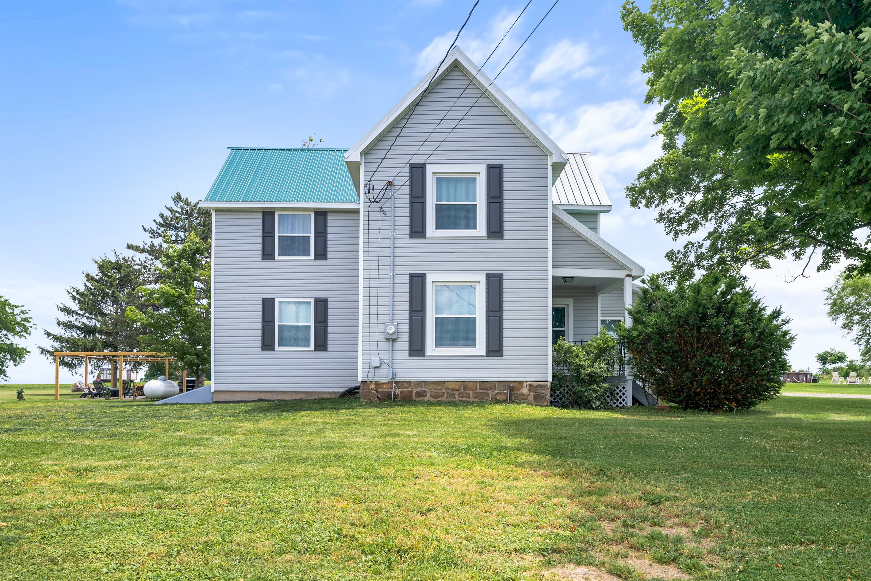 Two-story farmhouse with green metal roof