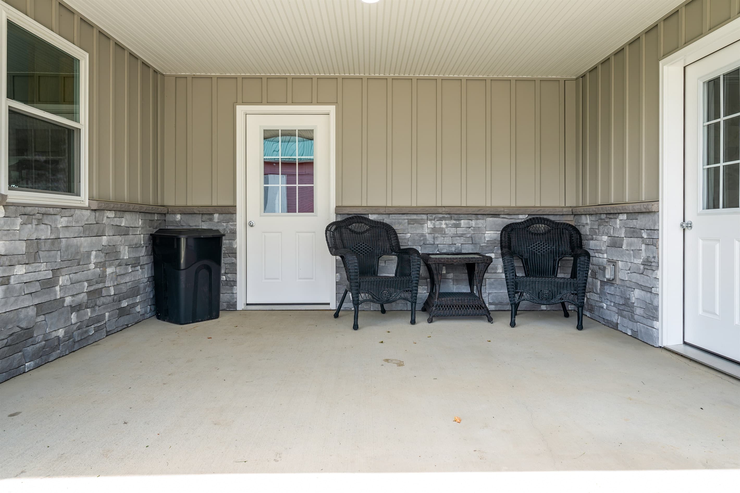 Covered porch with two Adirondack chairs

