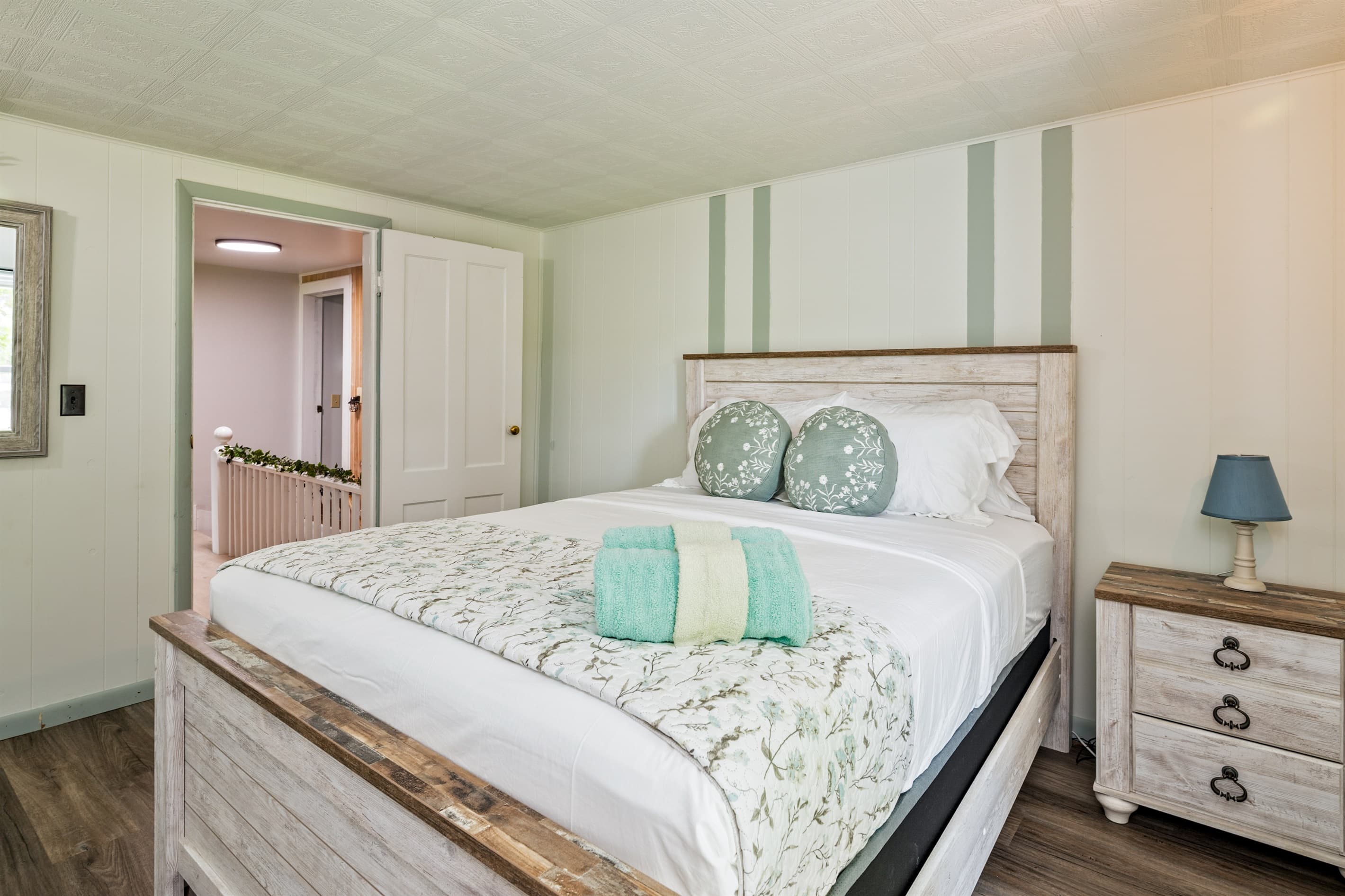 Bedroom with wooden framed bed and pastel bedding