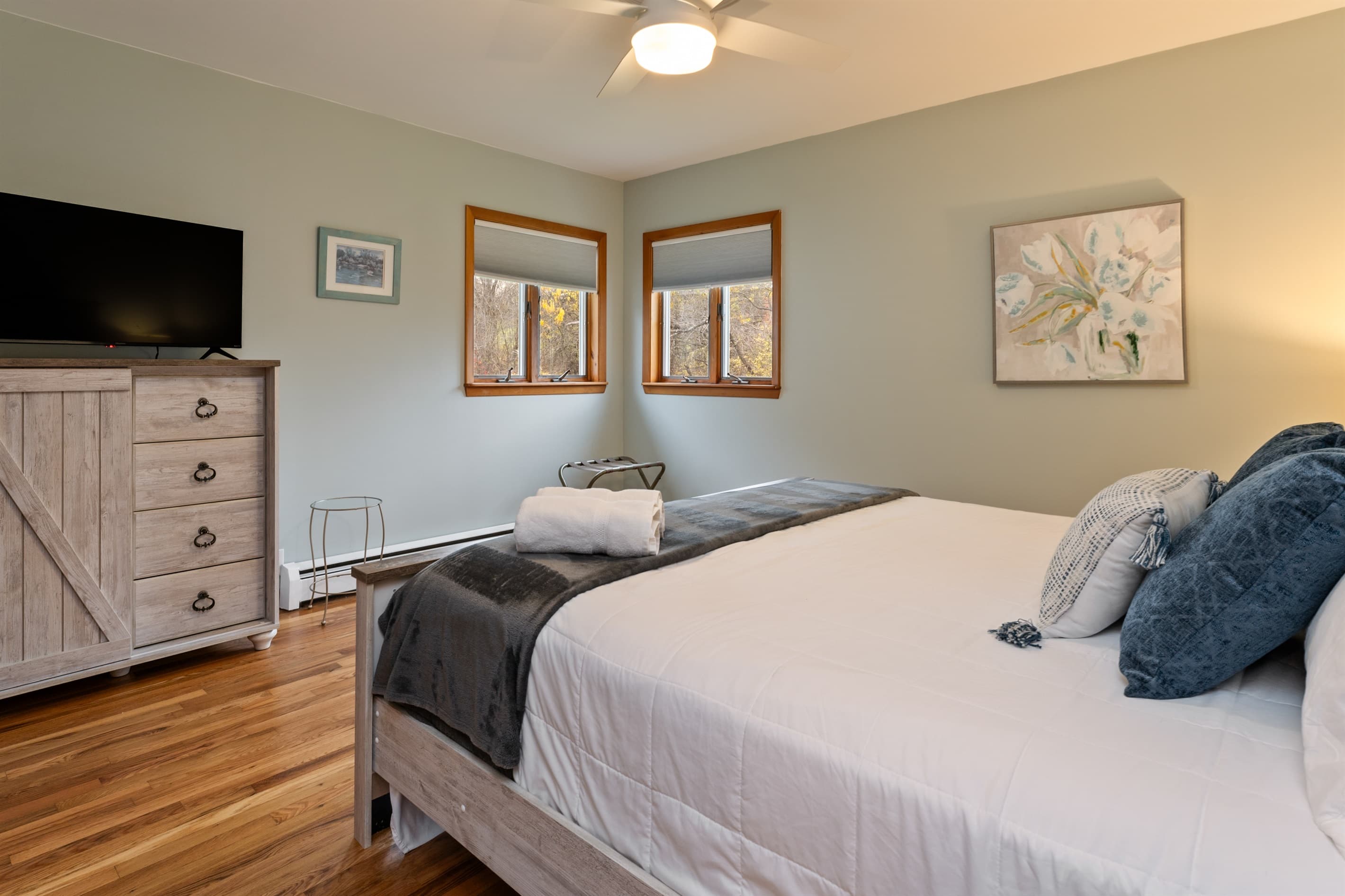 King bedroom with television and hardwood floors