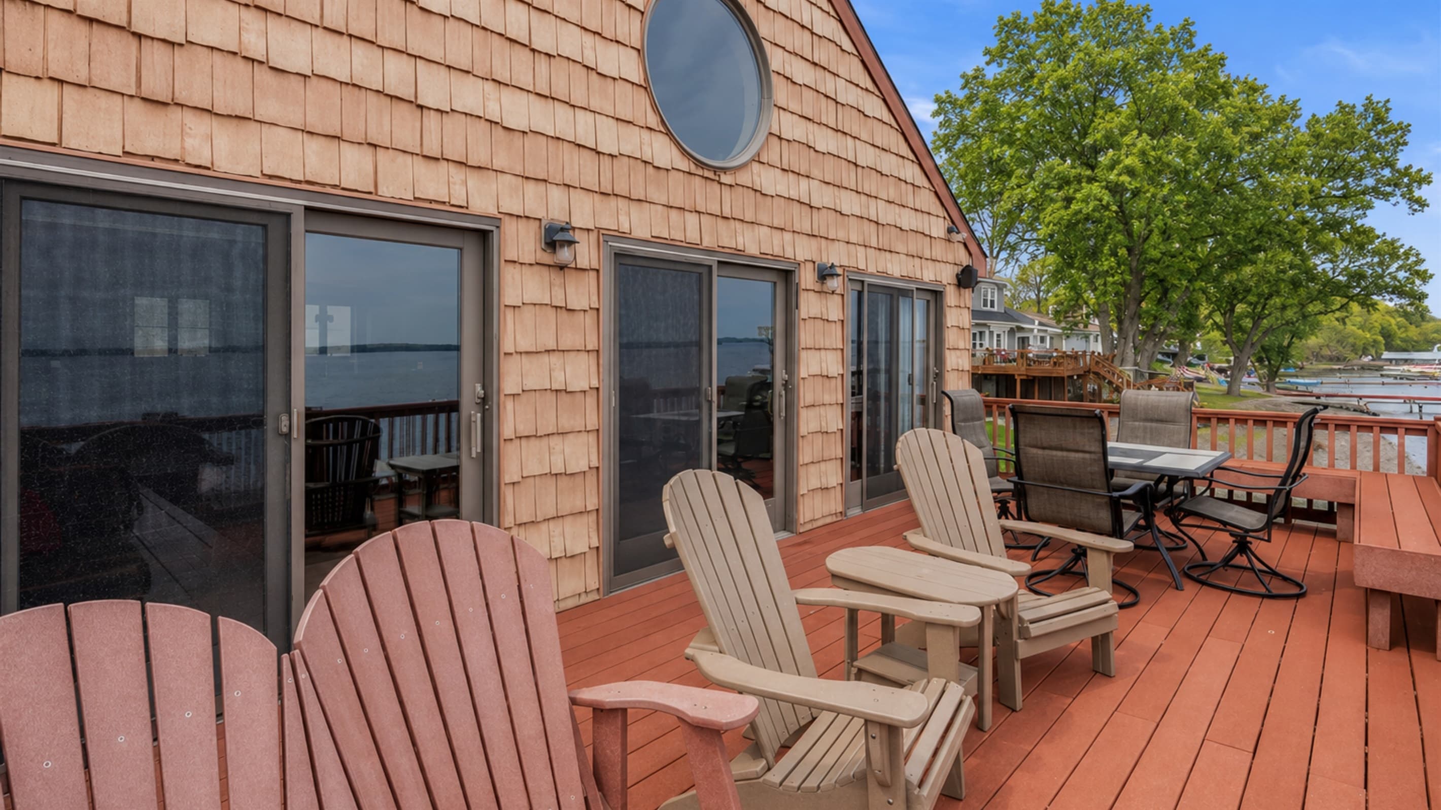 Spacious deck with Adirondack chairs and dining area