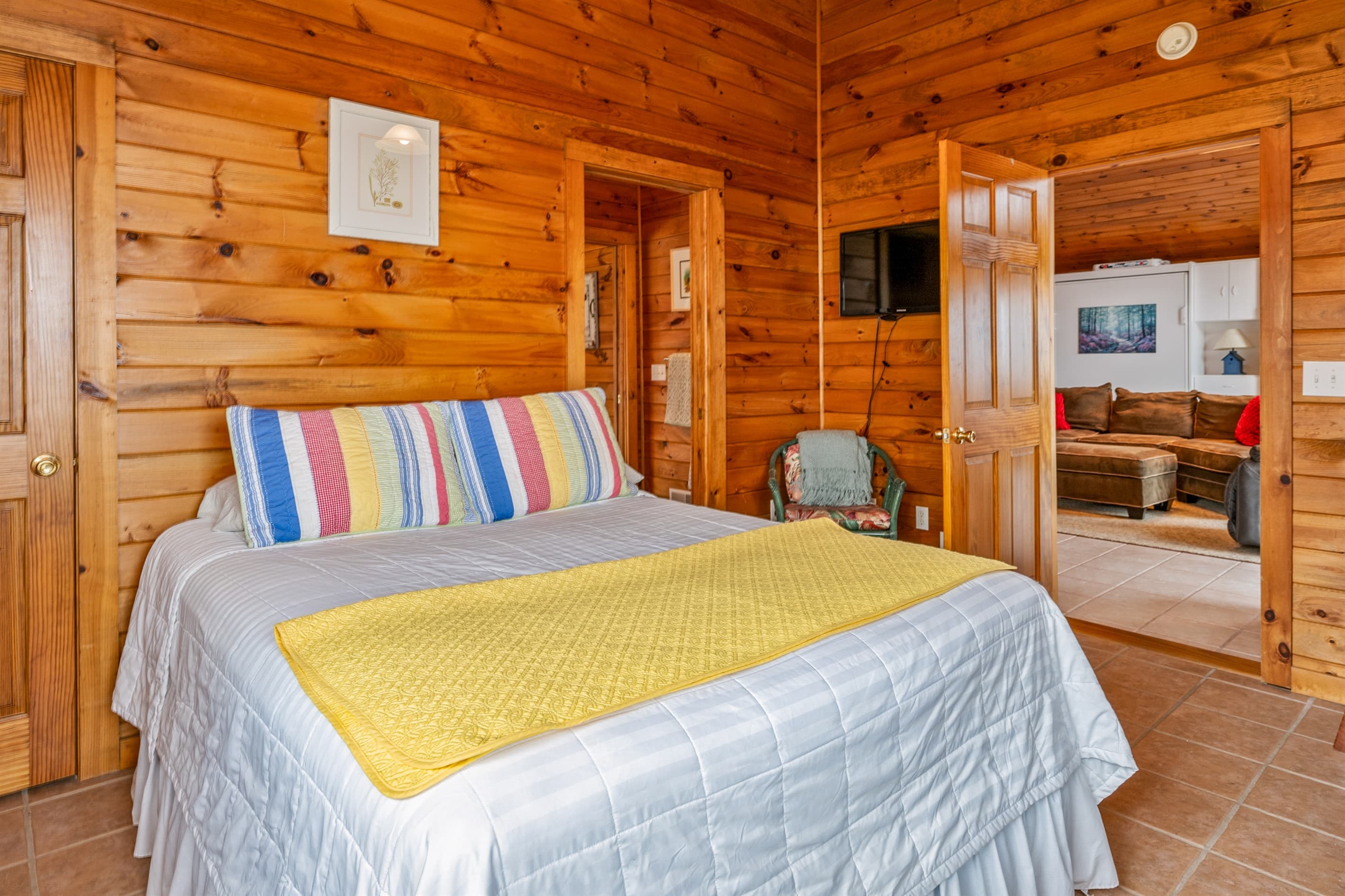 Bedroom with colorful bedding and television