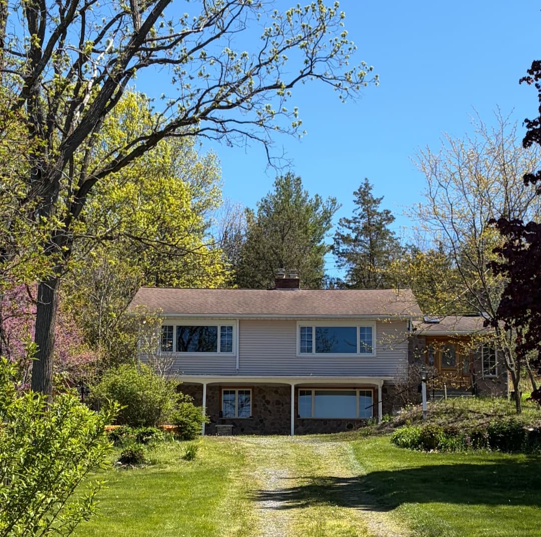 Two-story home surrounded by mature trees