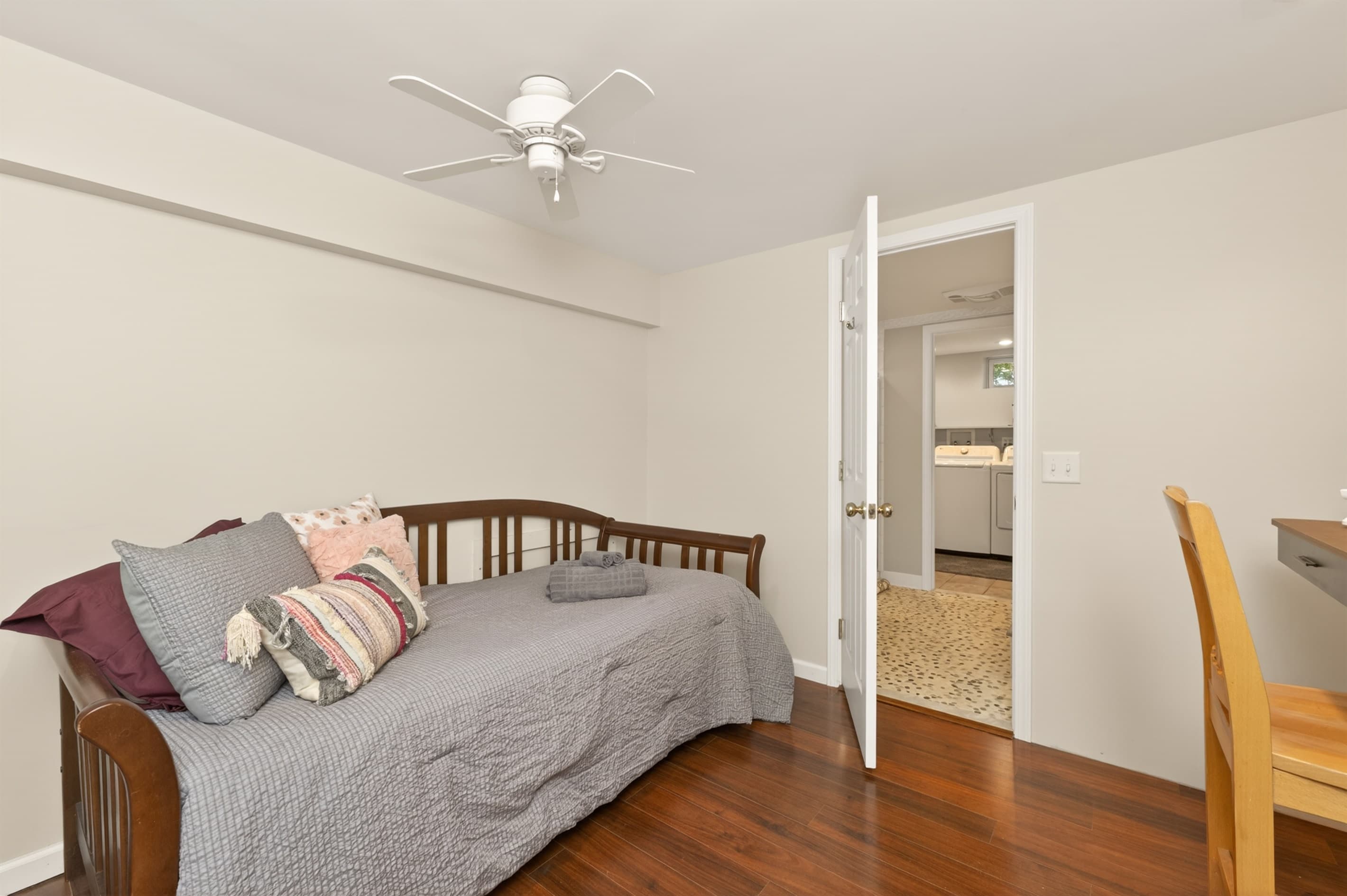 Bedroom with gray bedding and wooden floors