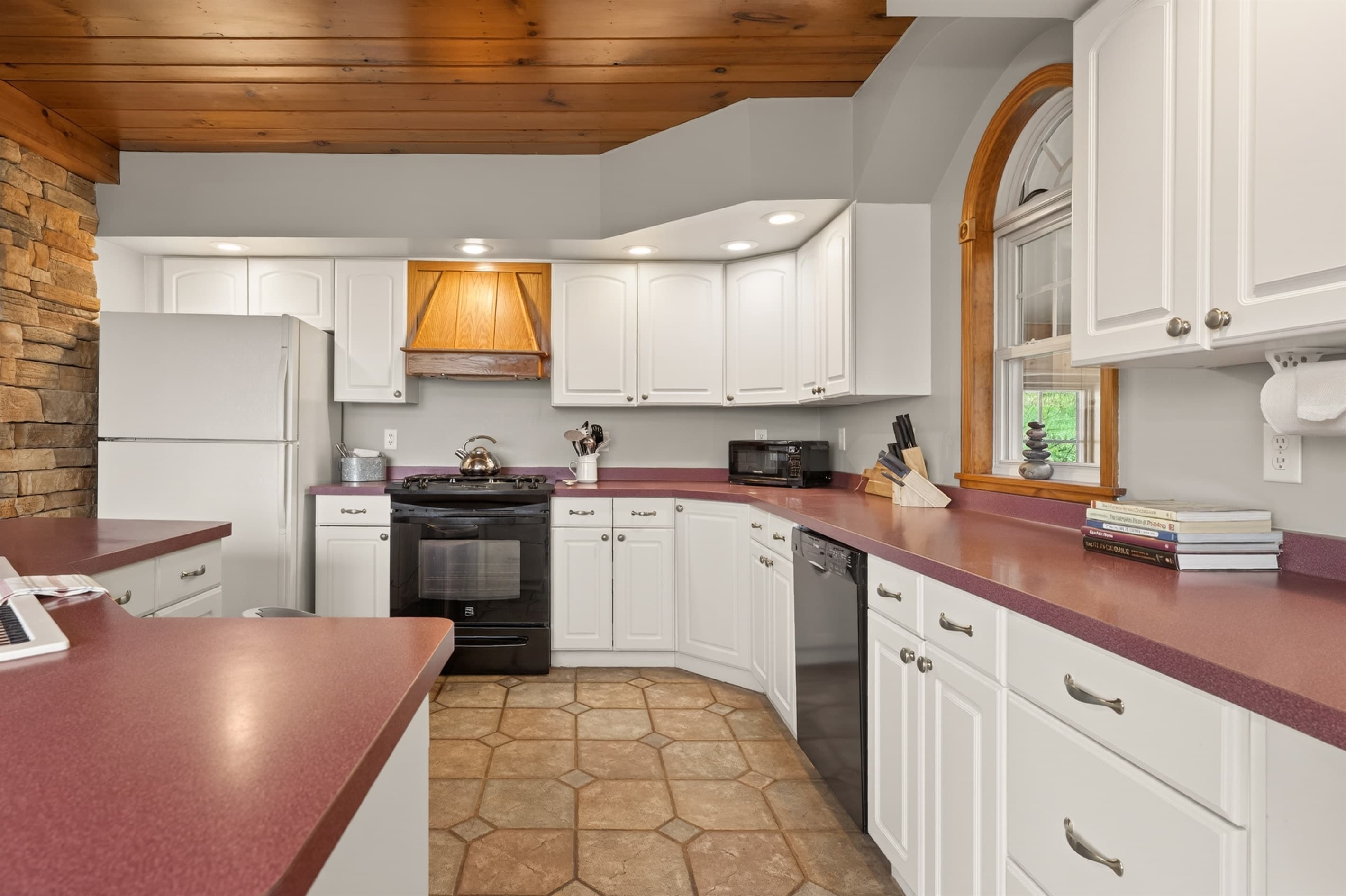 Kitchen with white cabinetry and red counters