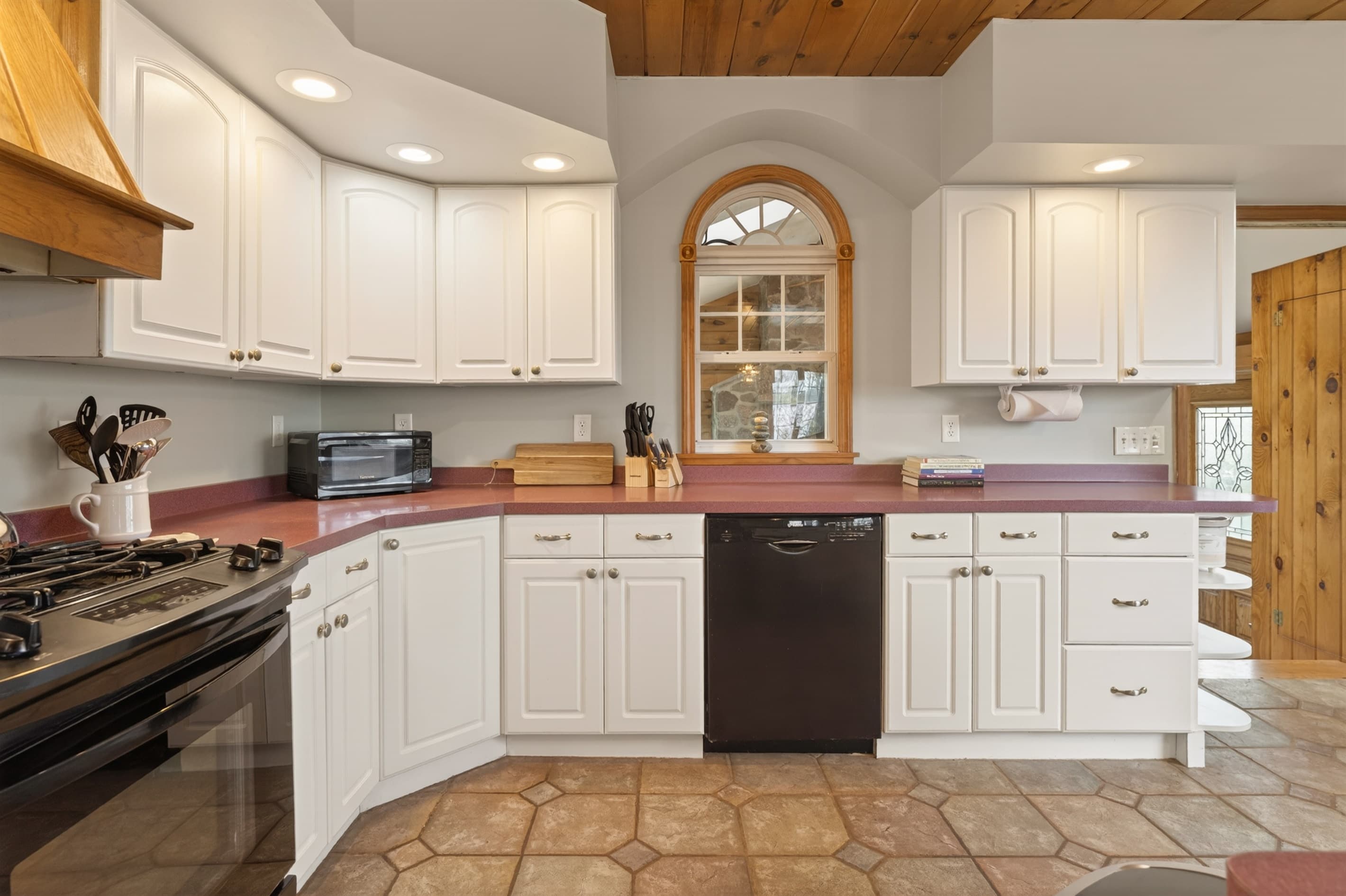 Kitchen sink beneath an arched mirror