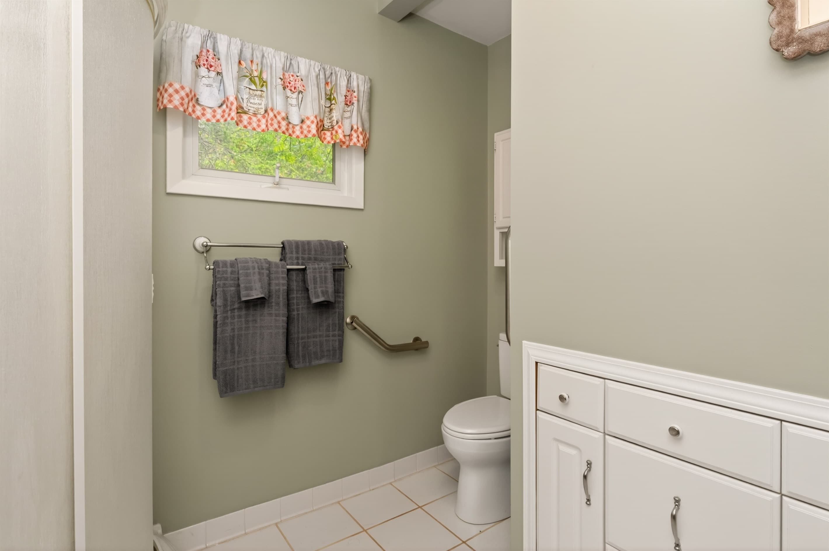 Toilet and vanity beneath wall-mounted storage