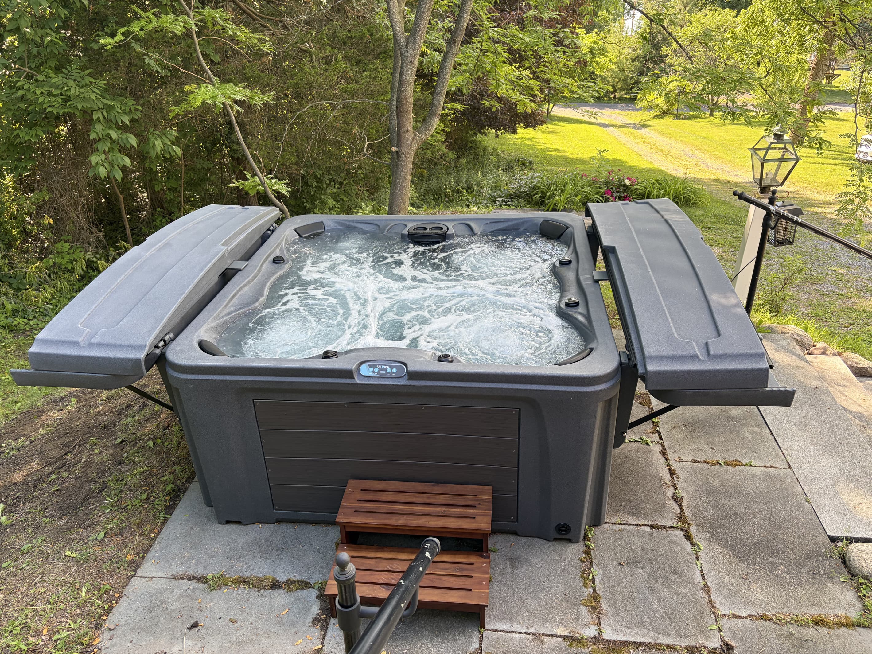 Outdoor hot tub beside the wooded yard