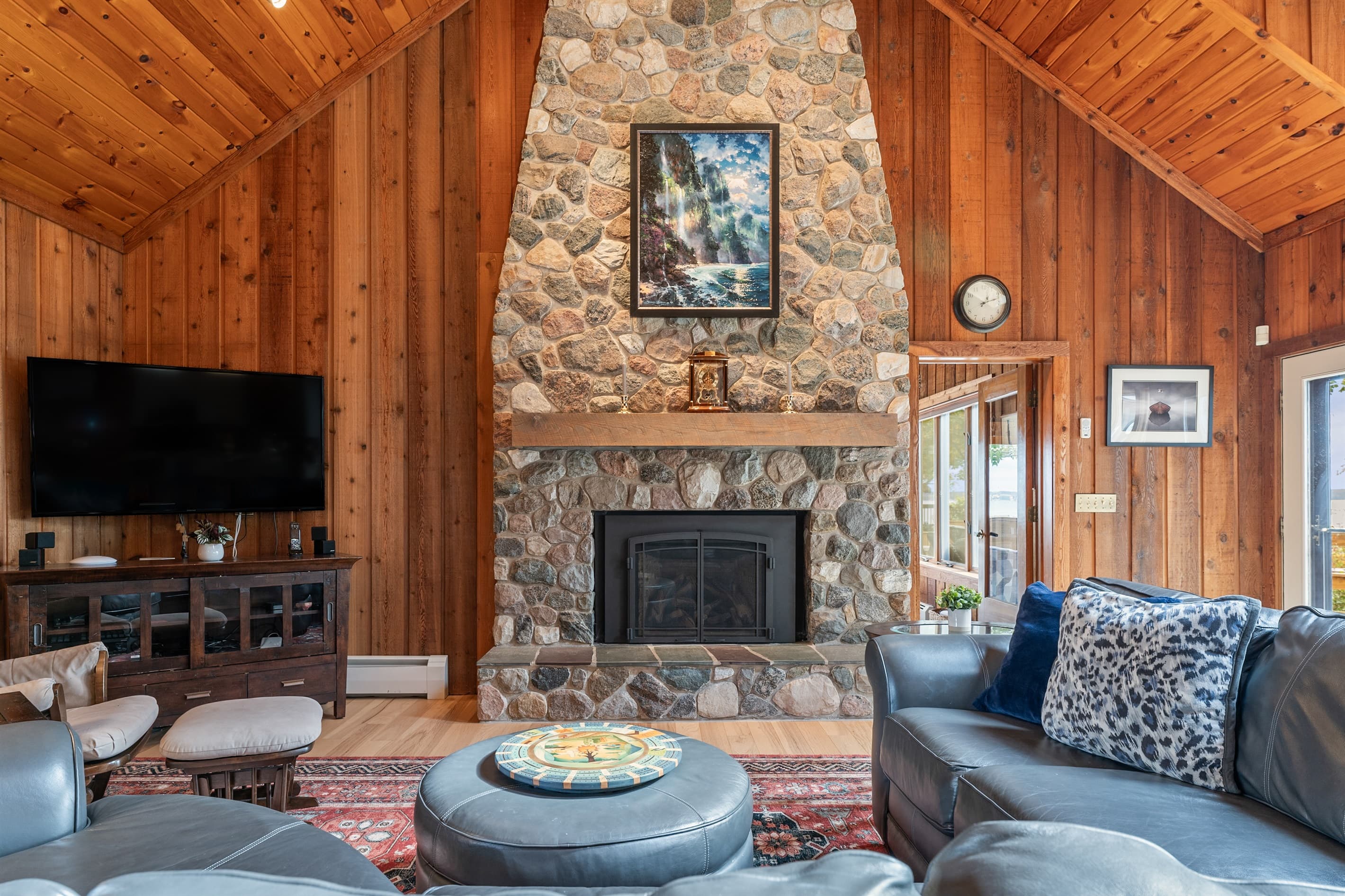 Stone fireplace with television and lounge seating