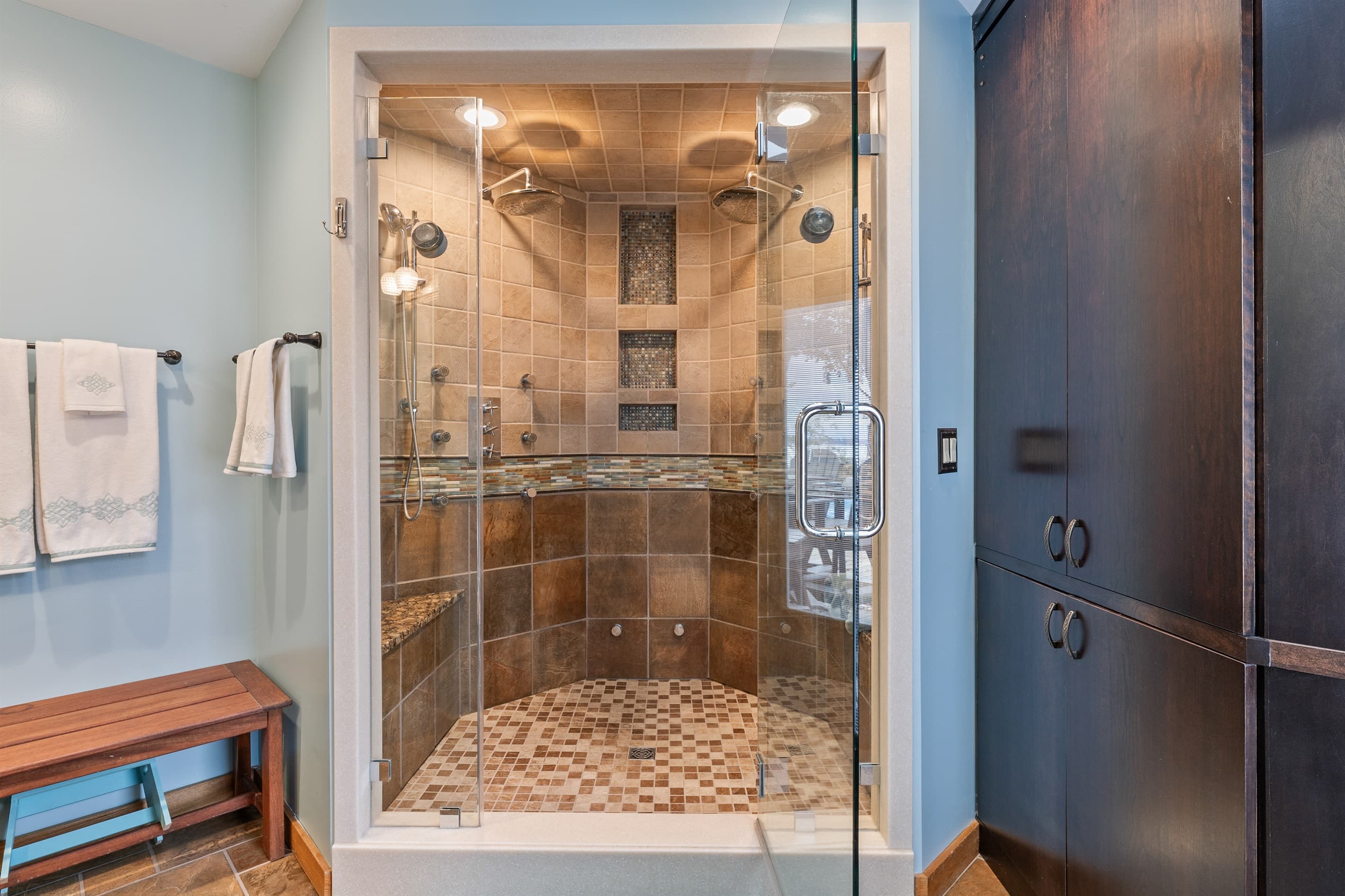 Glass-enclosed shower with rainfall showerhead