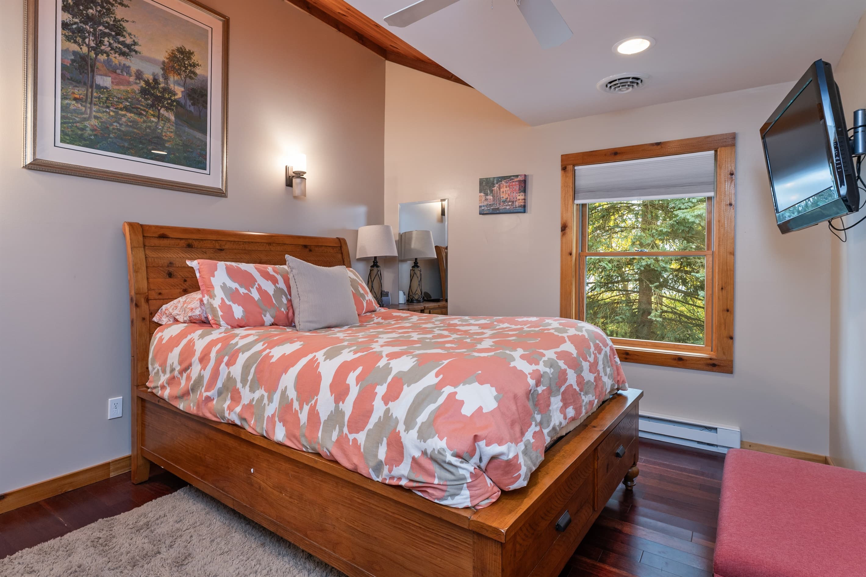 Bedroom with colorful bedding and wooded views