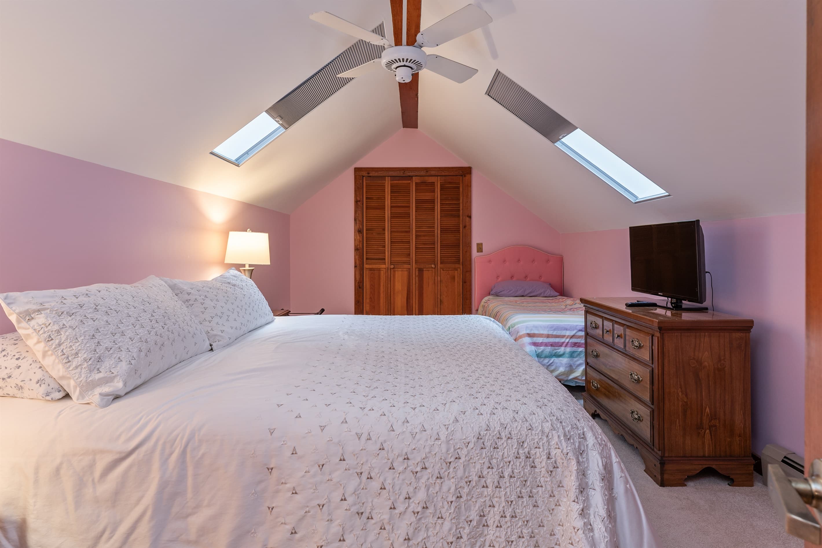 Loft bedroom with vaulted ceiling and skylights