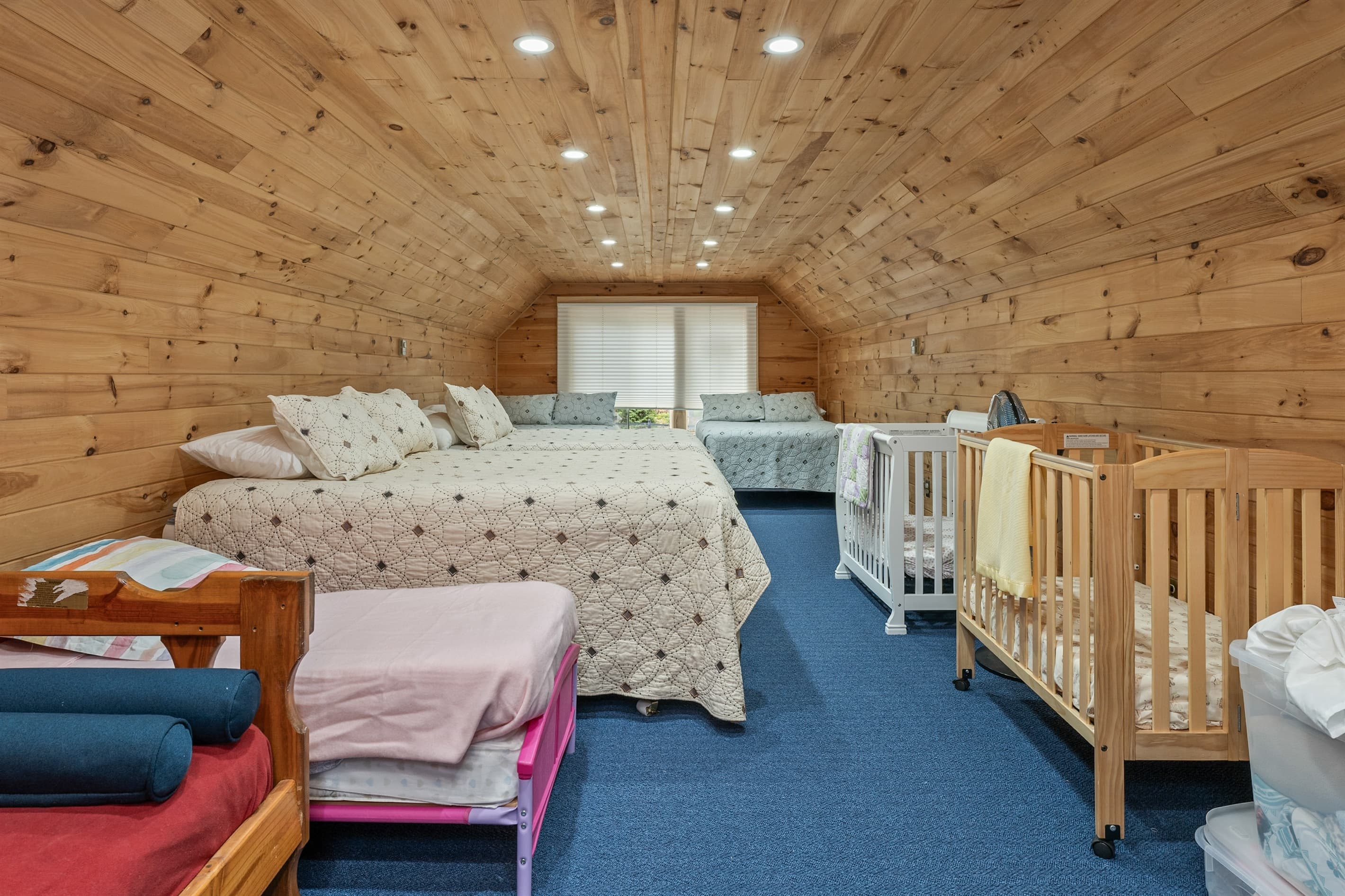 Spacious bunk room with cribs and beds