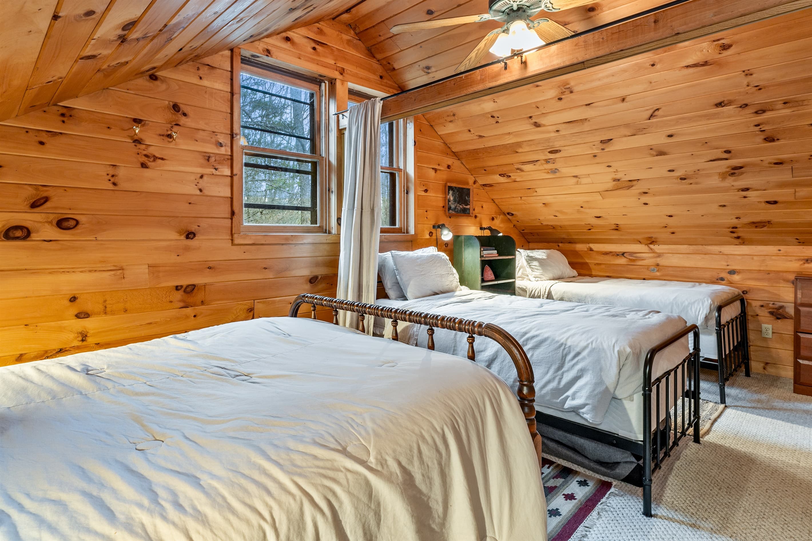 Bedroom with windows on wood walls
