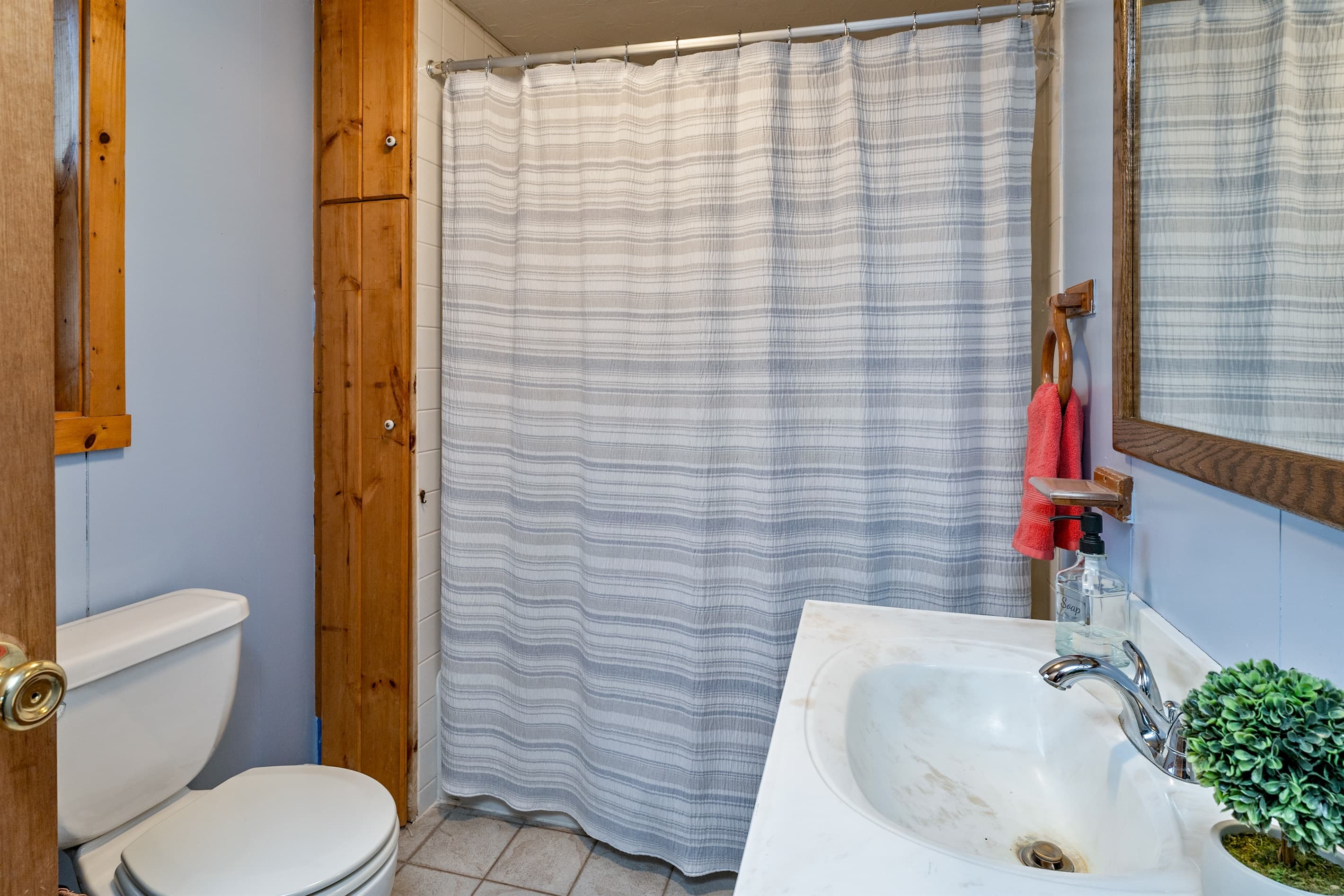 Bathroom with toilet and blue lined shower curtain