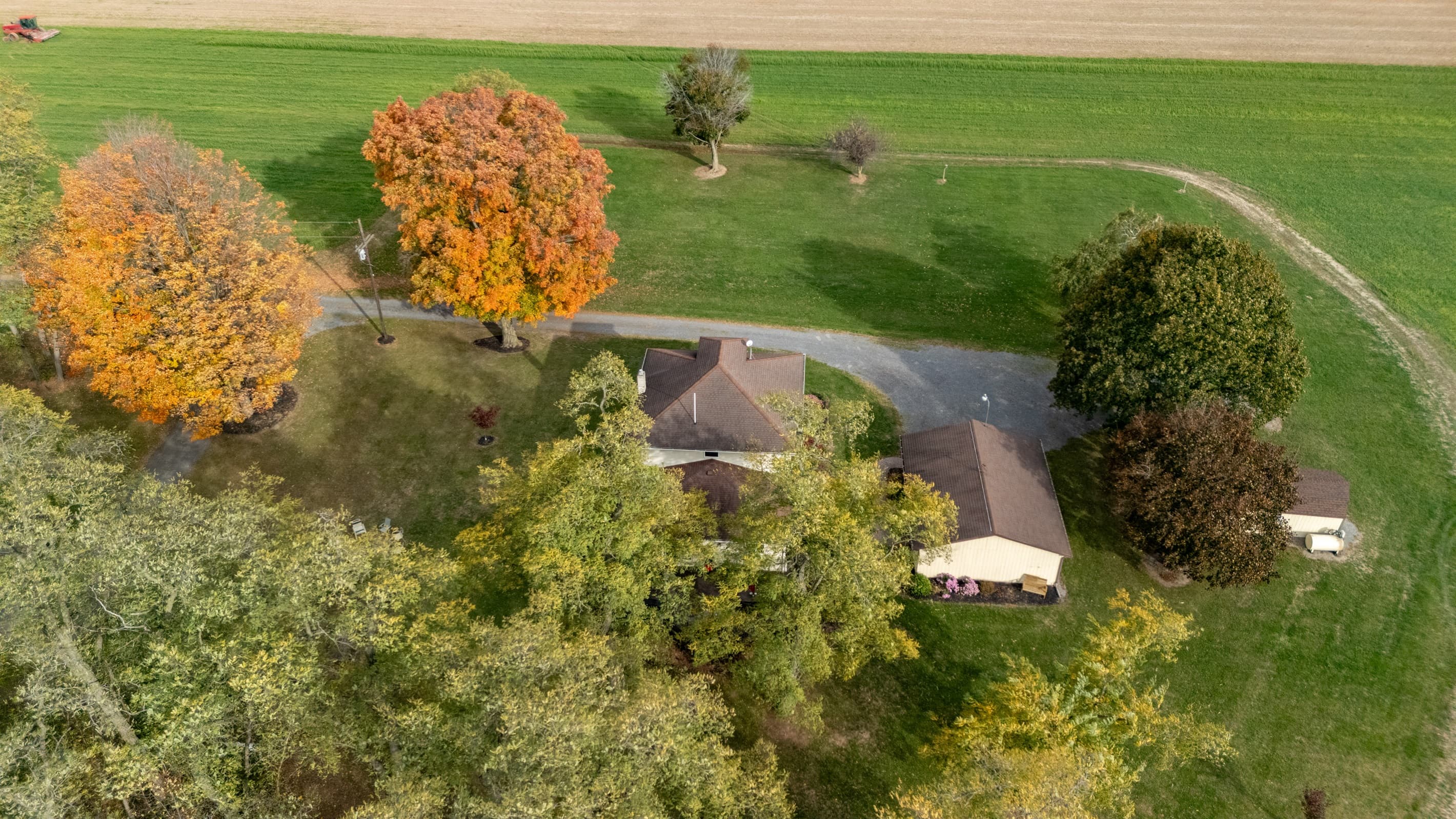 Farmhouse framed by colorful autumn trees