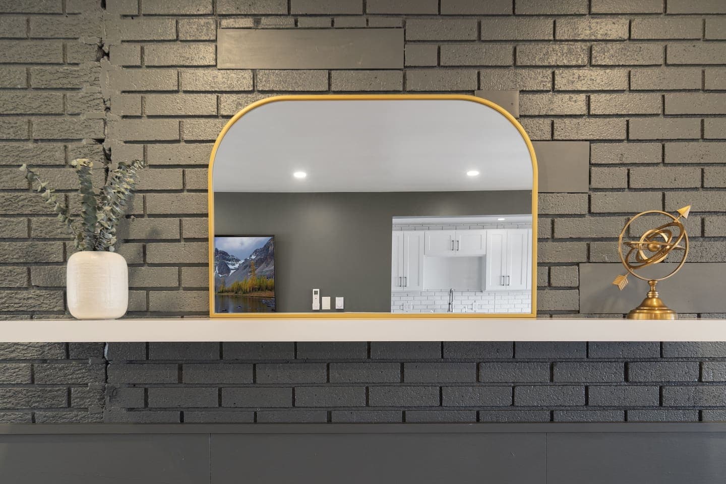 Decorative mirror above brick fireplace
