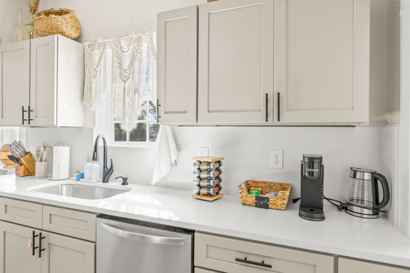 Streamlined kitchen counter w/ modern cabinetry, coffee setup, & everyday essentials close at hand.