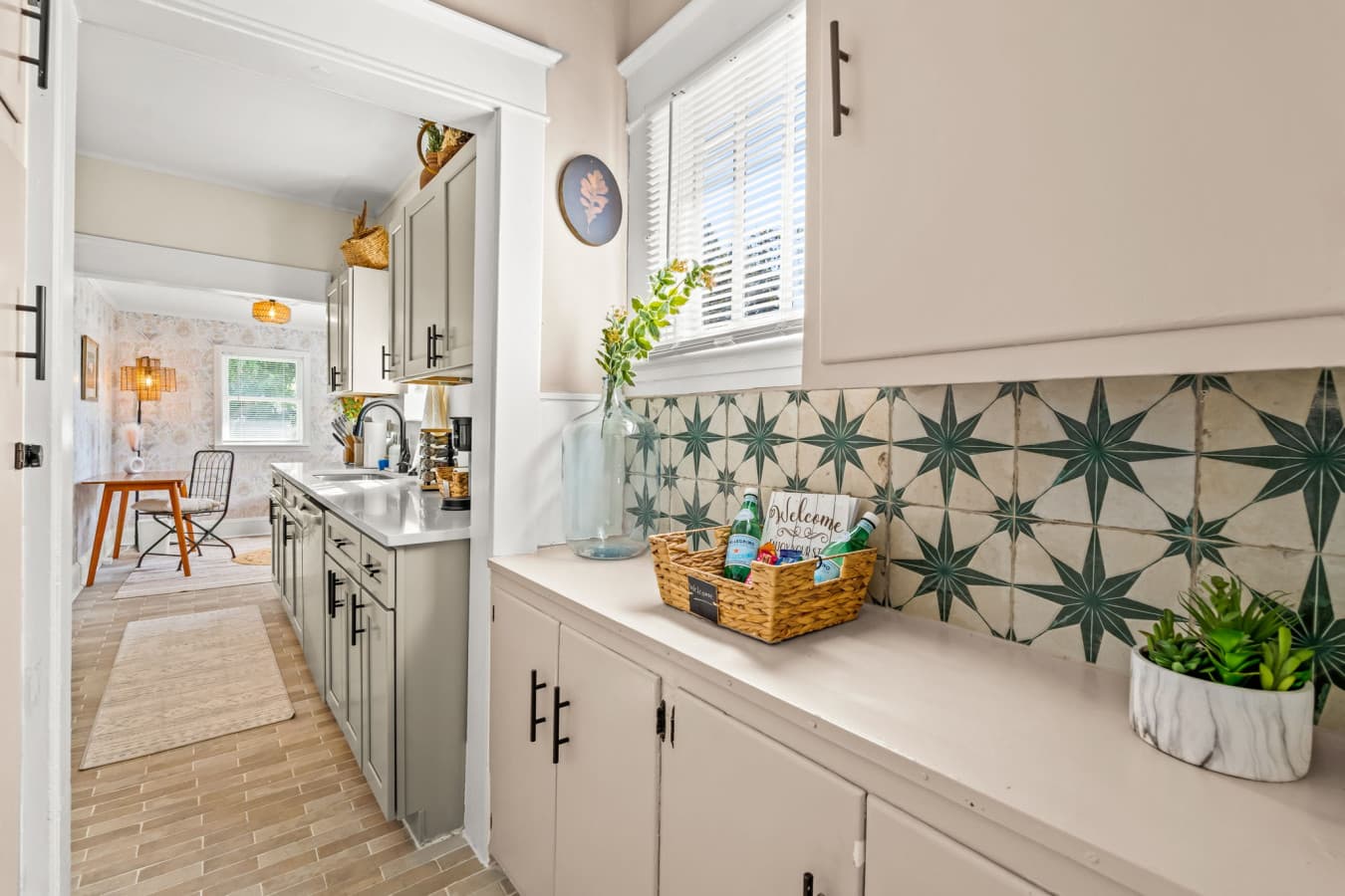 Bright kitchen corner w/ charming tile detail, greenery, & a sunny vibe that lifts everyday routines.