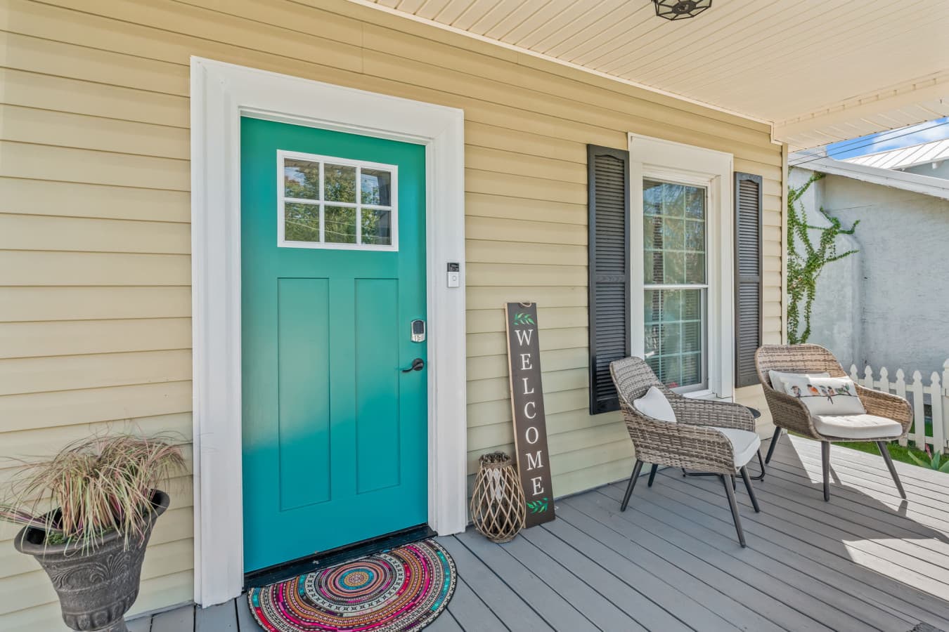 Charming front entry w/ a pop of color, cozy porch details, & an inviting first impression.
