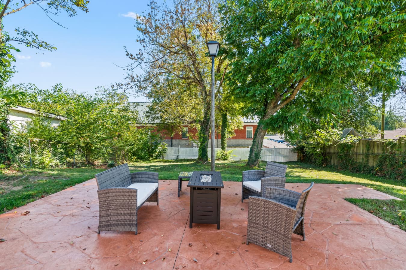 Outdoor patio w/ seating under mature trees, perfect for laid-back afternoons.