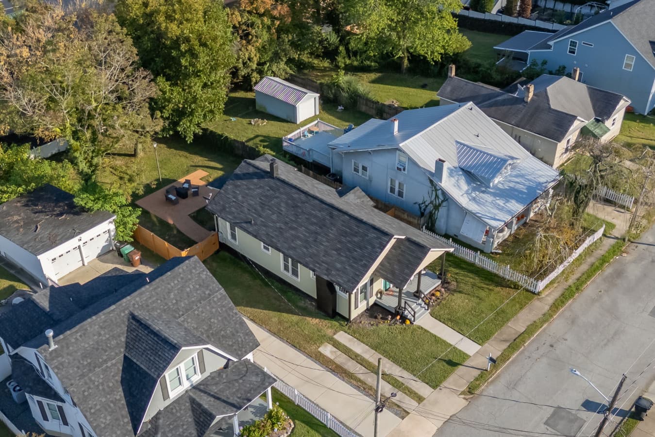 Overhead view highlighting the home’s roofline & surrounding properties.