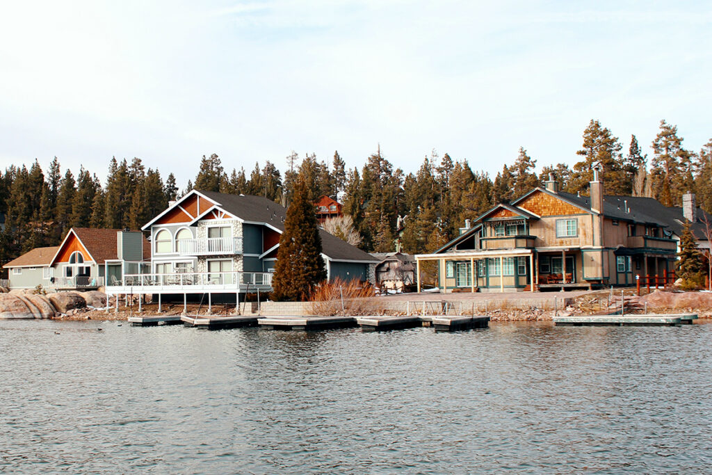 A row of short-term rental lake houses in front of evergreen trees.